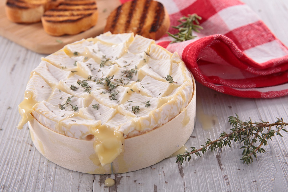 brânză Camembert coaptă, servită alături de pâine - una din cele mai faimoase tipuri de brânzeturi