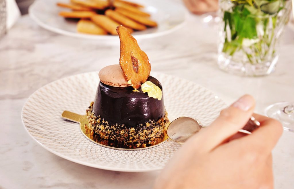 prăjitură cu ciocolta Poirot de la Zexe Braserie, sub forma unii butoias glazurat, cu o felie de para deshidratata in varf