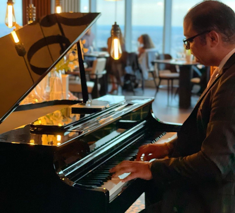 prim plan cu un pianist care canta la pian in restaurant NOR