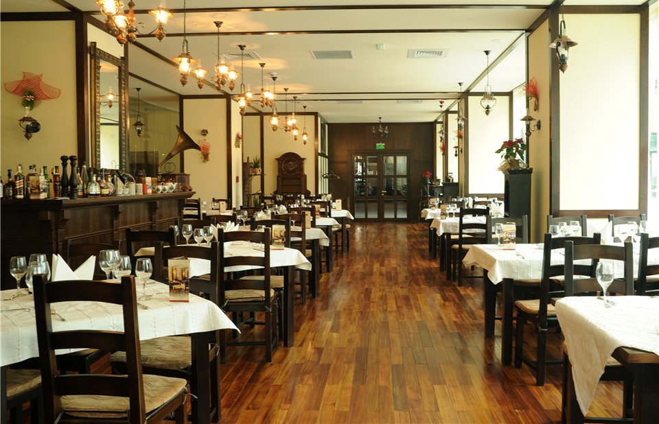 Privire de ansamblu din Restaurant Tirol Sinaia, cu mese aliniate pe stanga si pe dreapta, intr-un decor elegant