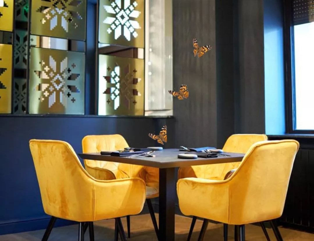 masa patrata cu patru scaune capitonate in galben si oglinzi cu model de floare la restaurant Grai Bucuresti