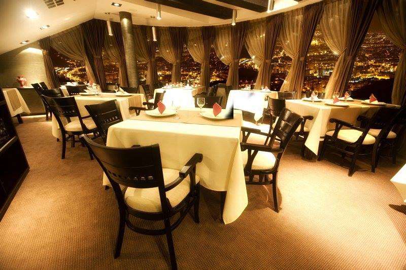 Restaurant Belvedere din Brașov, fotografiat seara, cu interior elegant si salon circular cu ferestre mari prin care se vede de sus orașul plin de lumini