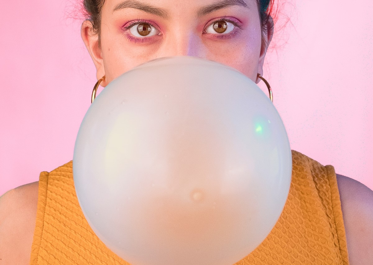 close up cu o fata care face un balon foarte mare din gumă de mestecat