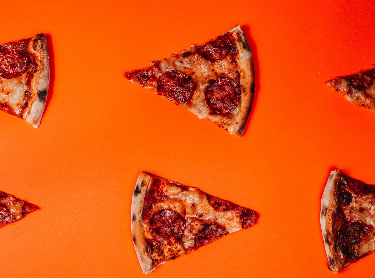 felii de piza fotografiate de sus, pe fundal portocaliu, ca imagine reprezentativă pentru alternativa sănătoasă la pizza