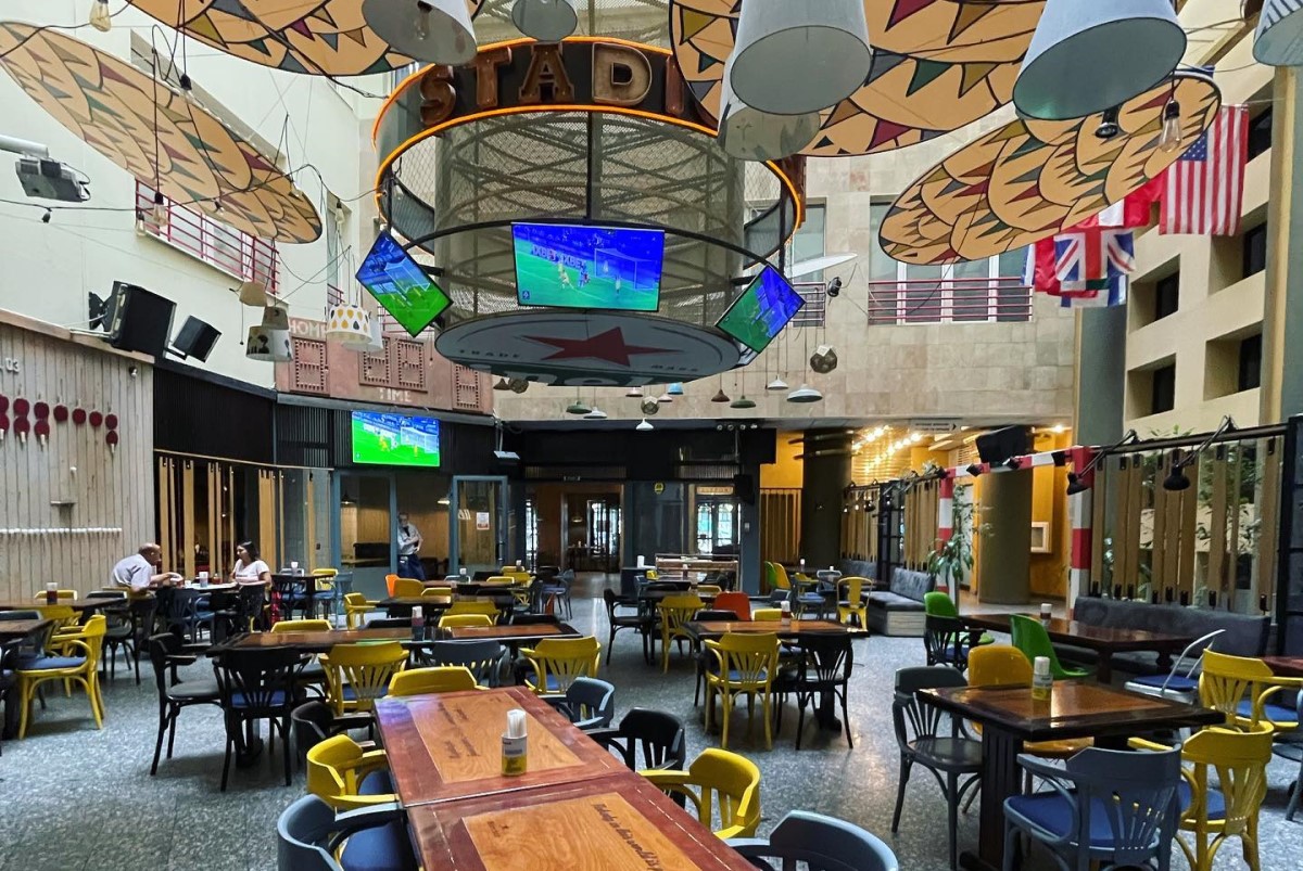 sala de mese de la restaurant Stadio, cu atrium, unde sunt suspendate ecrane TV la care poti urmari finala Champions Leaguea in București