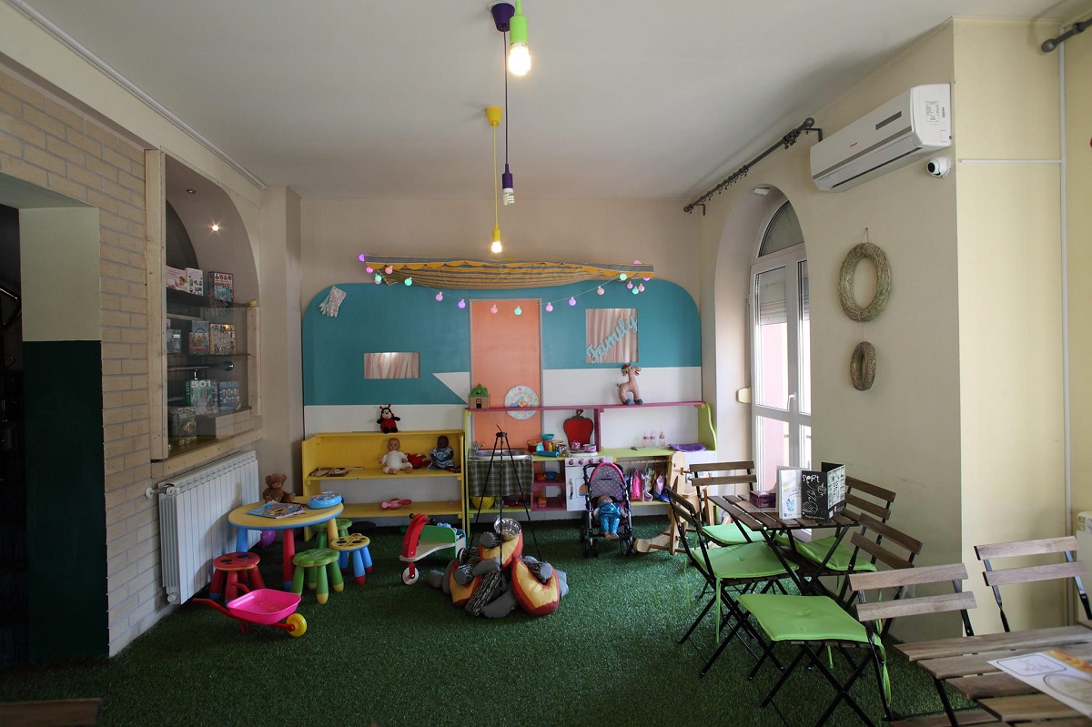 Imagine de ansamblu cu spatiul de joaca de la restaurant La Iris București, cu multe jucării pentru copii, mobilier de joacă și culori, unul din restaurante child friendly București