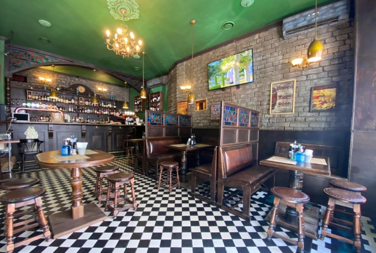 Primus Pub București, cu mobilier masiv din lemn, podea mozaic alb negru si tavan verde, cu televizor pe perete, und epoți urmări finala champions league în bucurești