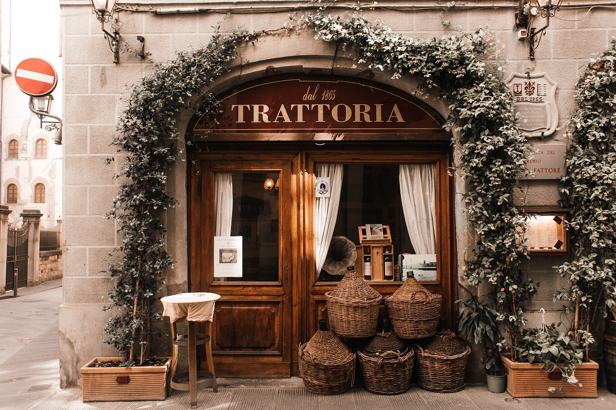 imagine cu intrarea intr-o trattoria, cu o bolta din flori agatatoare si cosuri de rachita in fata vitrinei, imagine pentru cele mai frumoase restaurante de la Roma