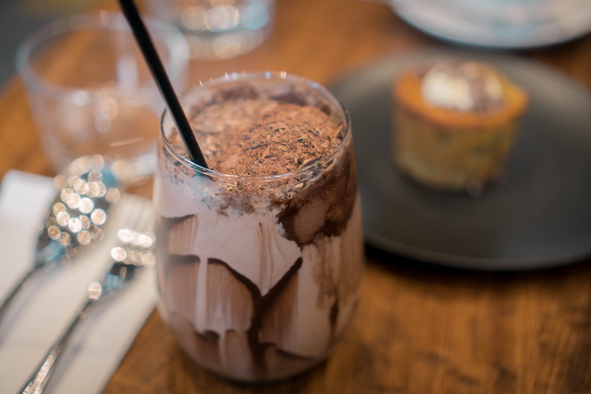 close up cu un pahar cu ciocolata cu lapte, cu par, si fundal blurat