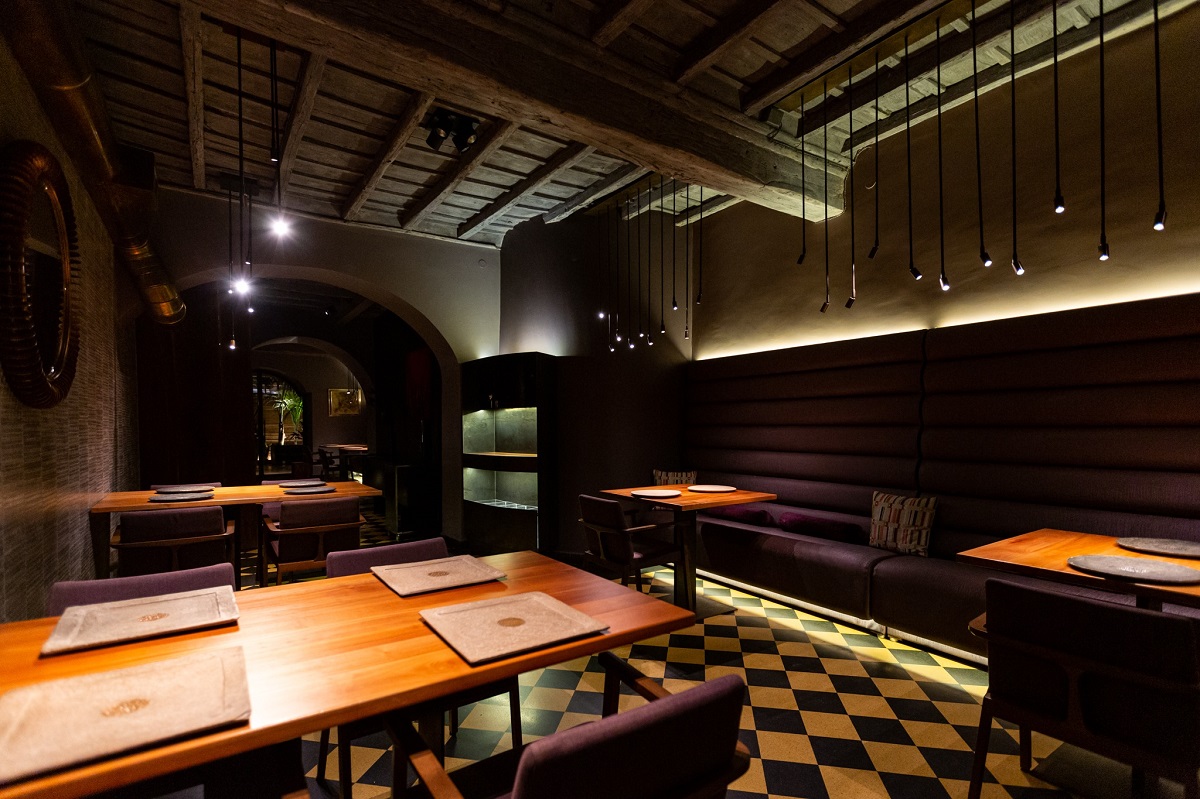 sala de mese de la Il Pagliaccio din Roma, cu mozaic pe jos, mese din lemn, canapele catifelate mov si sala iluminata discret, unul dintre cele mai bune restaurante de la Roma