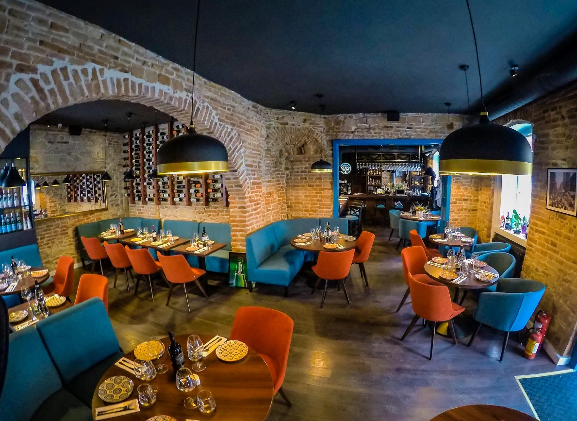 Restaurant Ciao New York unde mănânci bine în Cluj, cu bolta si pereti din caramida aparenta , mobilier modern  si scaune albastre si portocalii