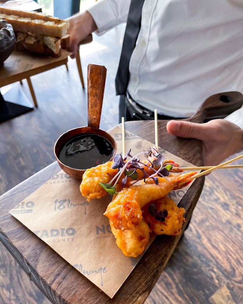 creveți tempurah serviti alaturi de sos, de catre un ospatar