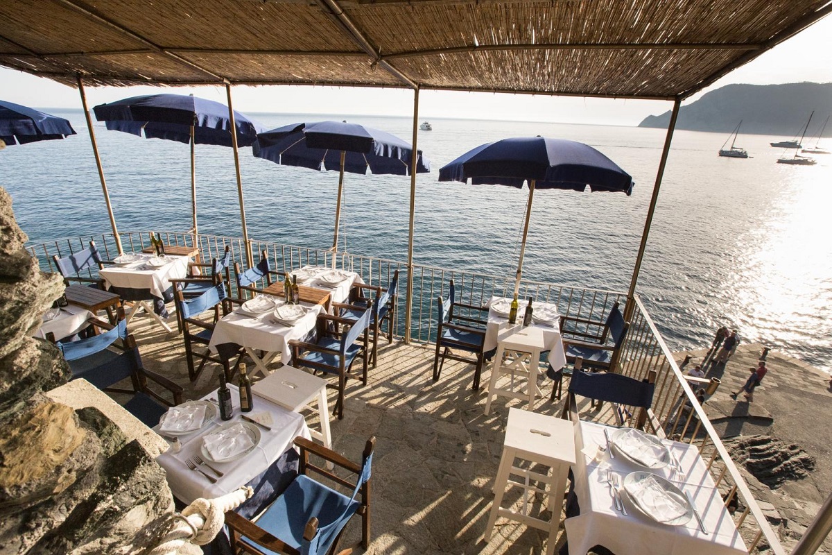 terasa pe stanca deasupra marii, cu umbrele albastre, la restaurant Belforte Vernazza