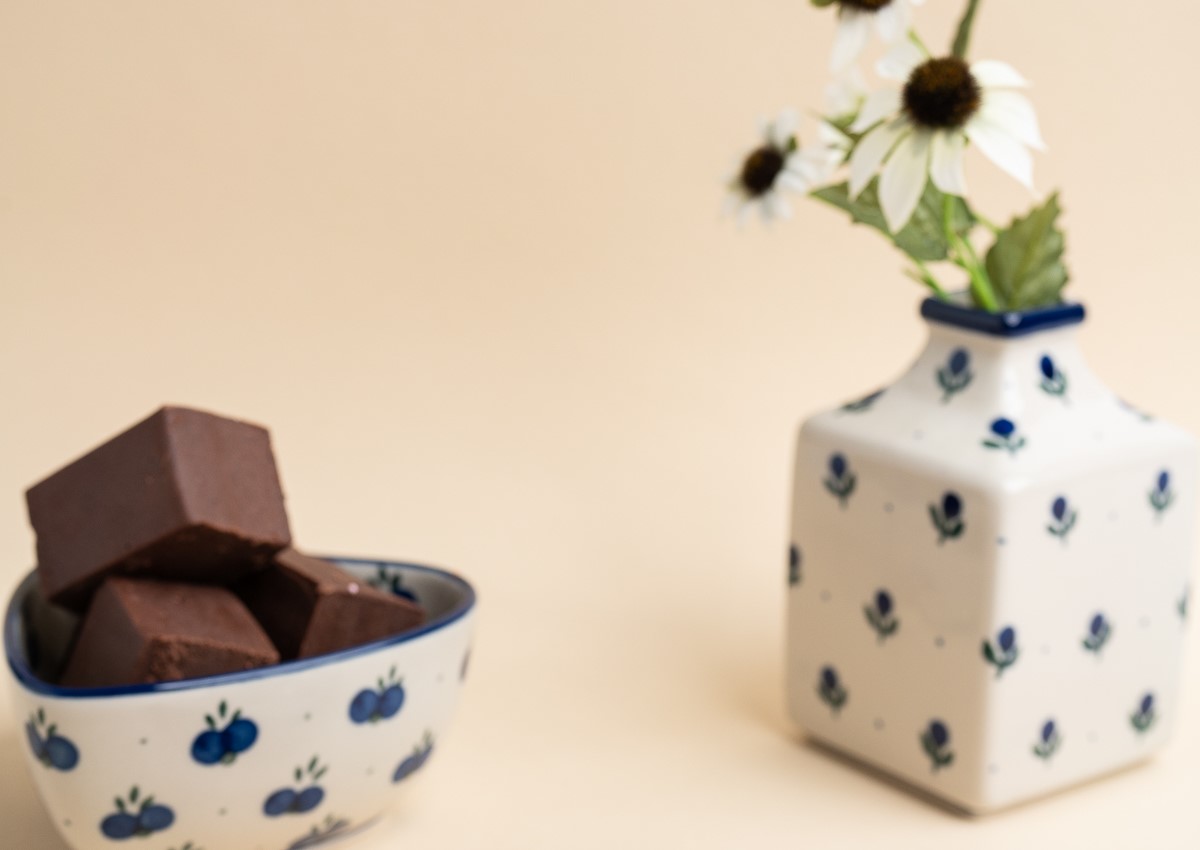 ciocolata de casa bucati, in castron alb cu desene albastre, langa o vaza cu flori, cu acelasi model, de la Mara Mura