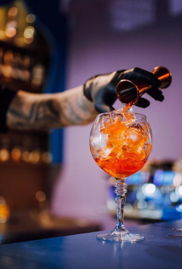 barman care prepara un cocktail portocaliu