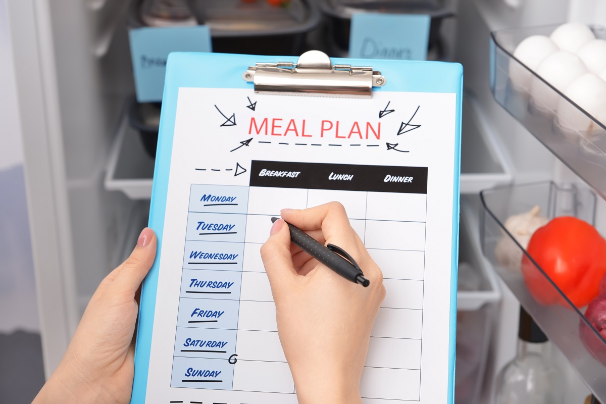 Woman making meal planning in kitchen on a flip chart