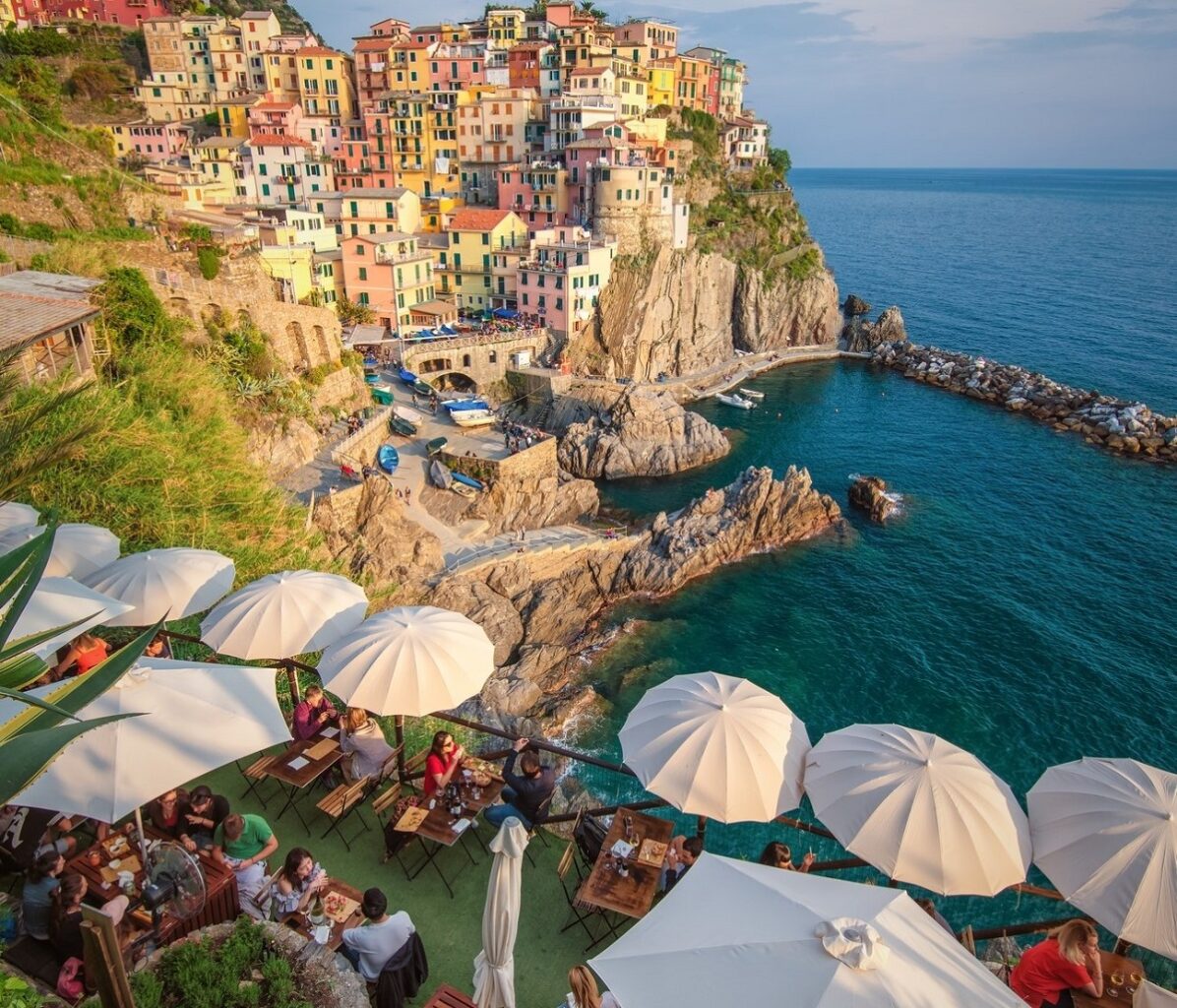 Nessun Dorma, unul din restaurante din Cinque Terre, amplasat sus pe marginea unei stanci, cu mese cu umbrelute albe, iar in departare marea si orasul Monterosso