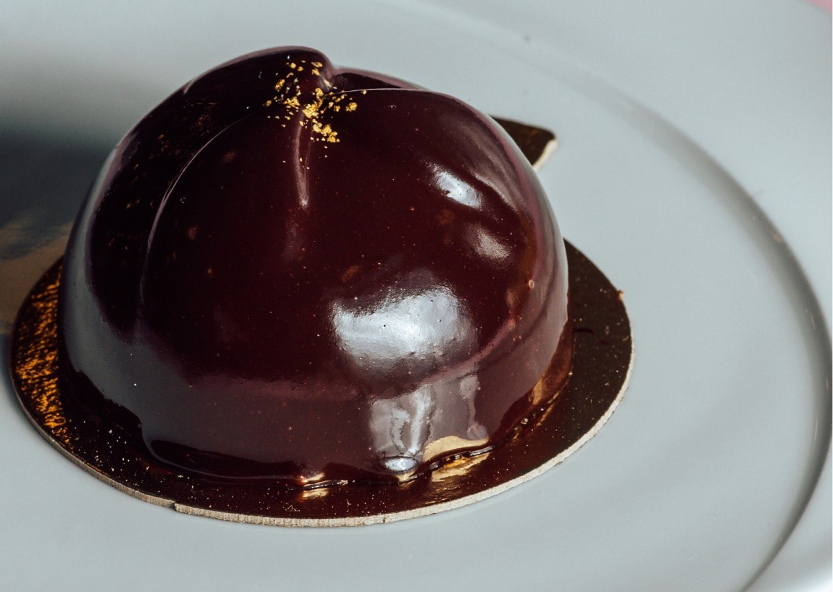 close up cu Chocolate Mousse del la Reper by Ess, sub forma de bila rotunda, asezata pe farfurie albă