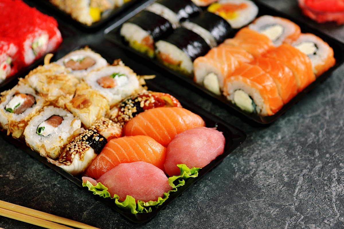 platouri cu diverse feluri de sushi, pe fundal negru, mâncare pentru o seară cu prietenii