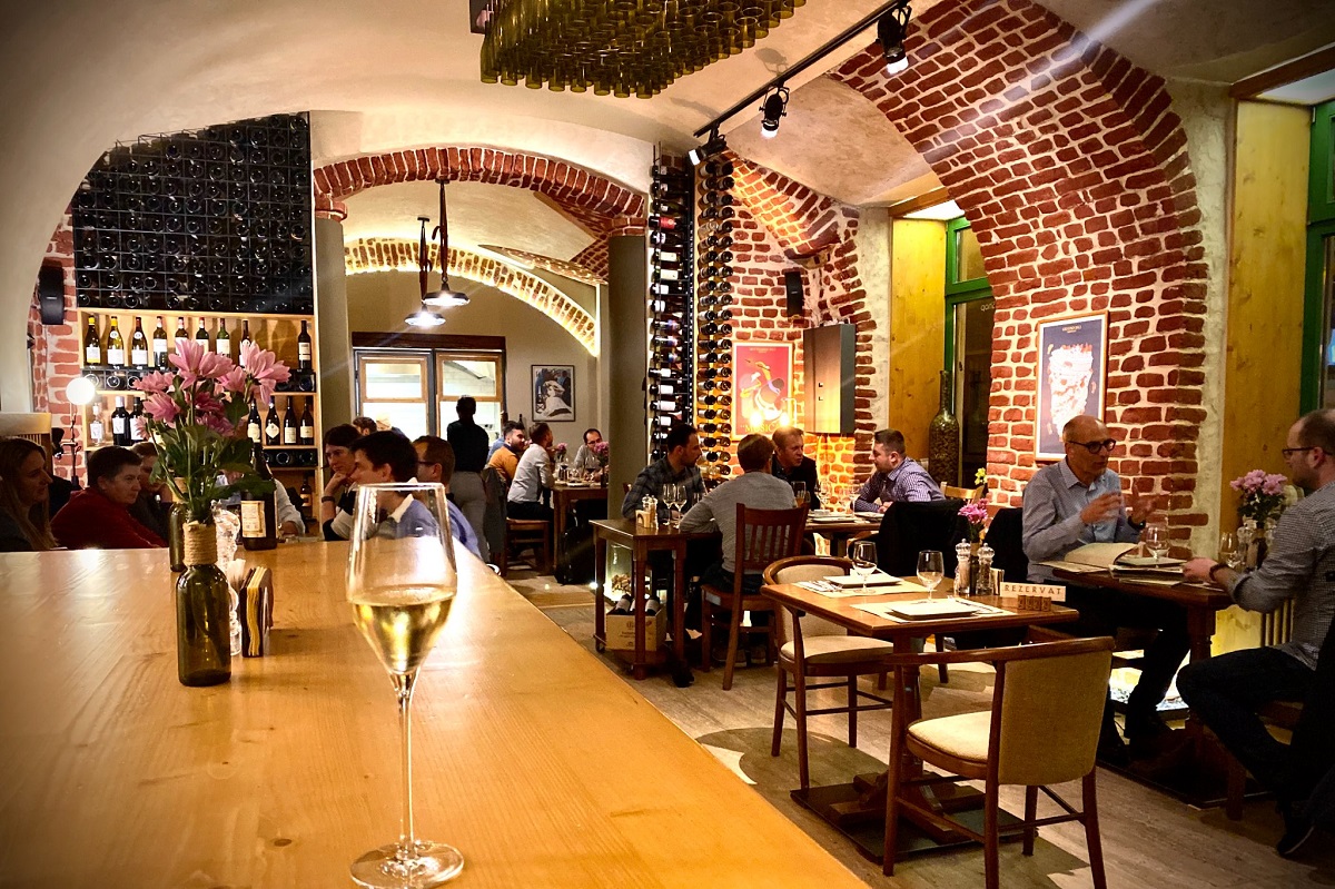 oameni care iau masa in restaurant cu pereti boltiti cu caramida aparenta la Vinto Gastro Wine unul din cele mai bune restaurante Timișoara