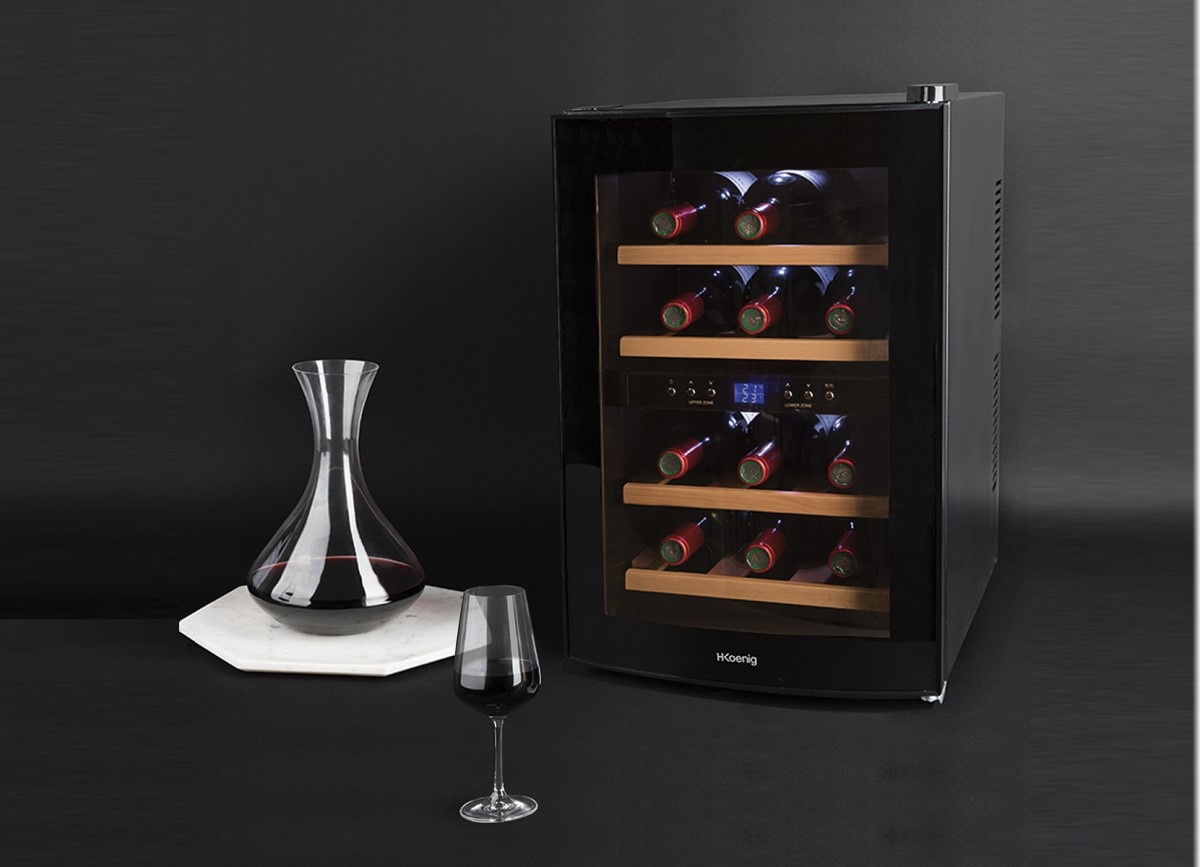 frigider vitrină pentru răcire sticle de vin, pe fundal negru, alaturi de un pahar de vin si un decantor