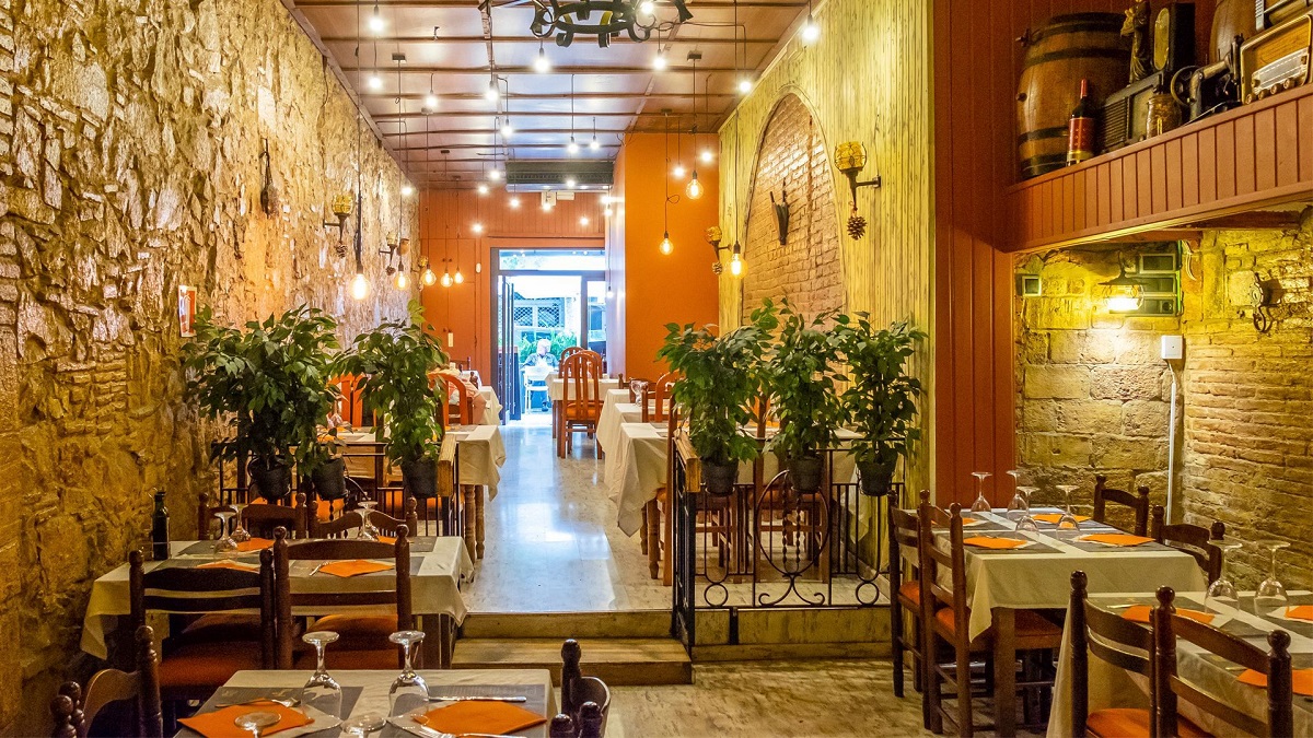 Interior restaurant Casa de Comidas Nogal cu pereti din piatra si becuri decorative - unde să mănânci în Barcelona