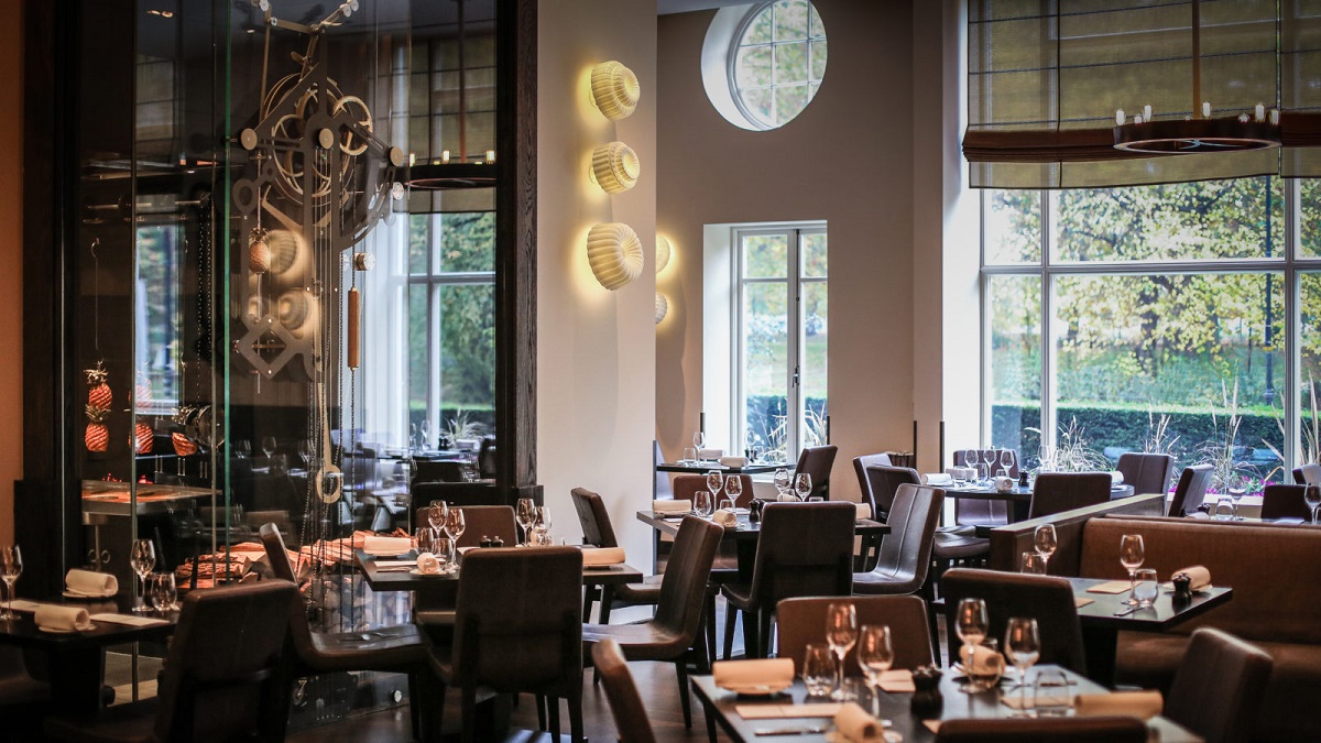 interiorul de la restaurant Dinner by Heston Blumental, cu design modern, luxos, copruri de iluminat moderne, scaune din piele si ferestre mari, pastrate. Restaurant und emâncăm în Londra
