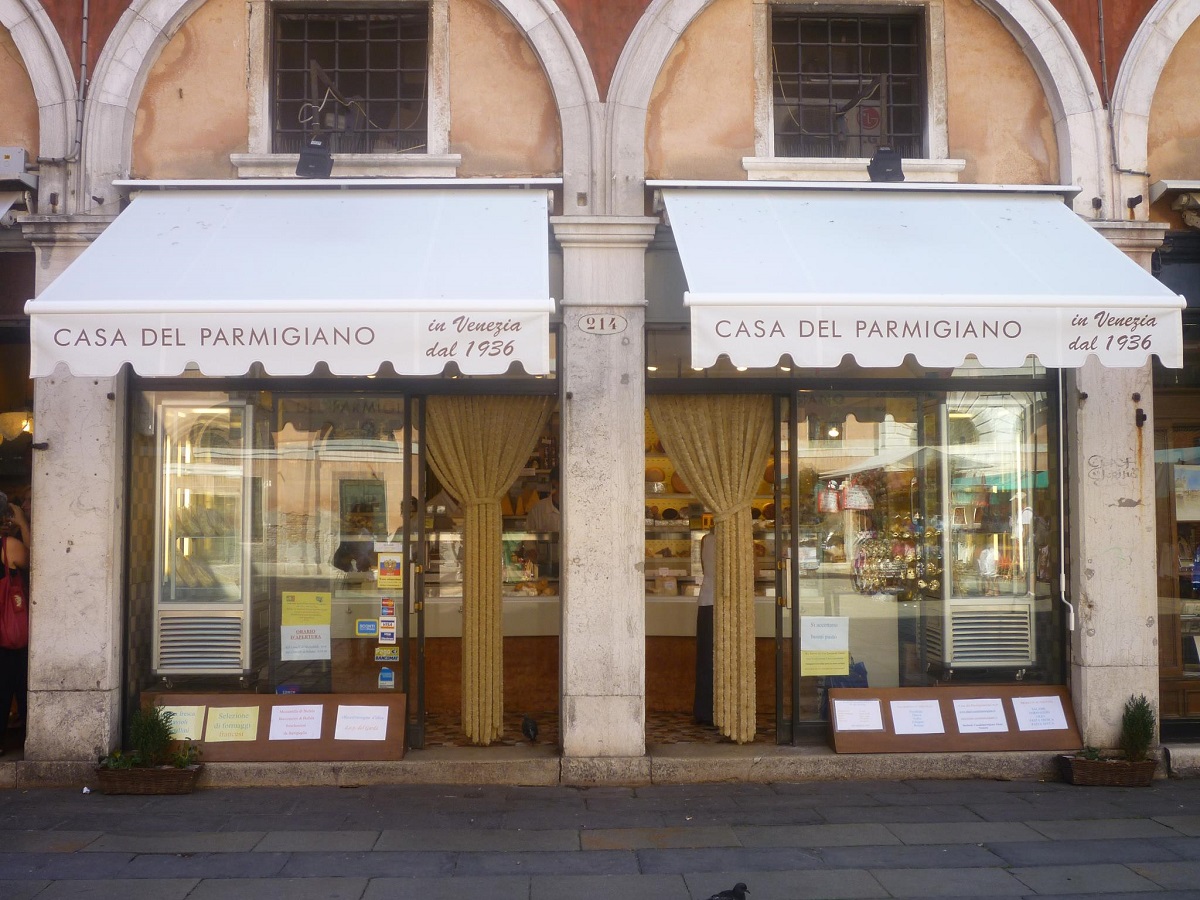 magazinul Aliani Casa del Parmigiano din Veneția, cu copertina alba si produse in vitrina, una din exoperiențe culinare inedite