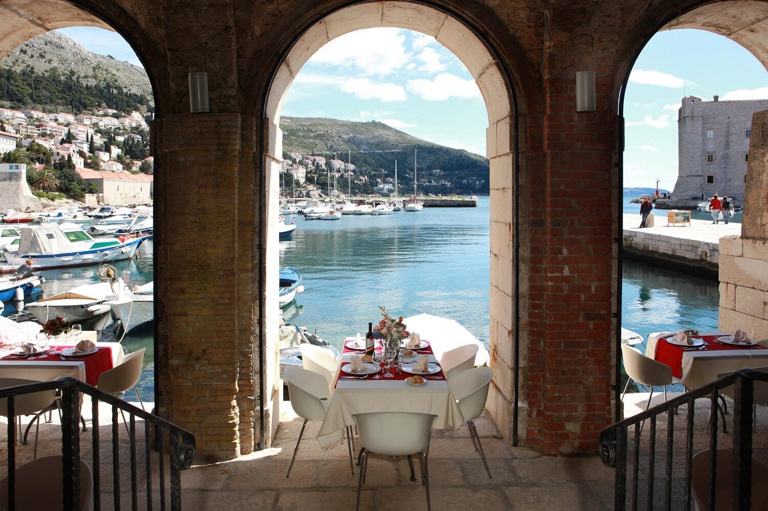 terasa  acoperita, cu ibolti din piatra prin care se vede marea, la restaurant Poklisar din Dubrovnik,  una  dine xperiențe culinare inedite