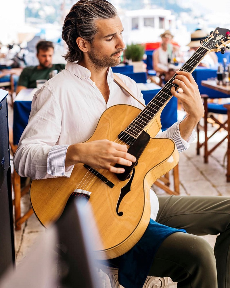 prim plan cu un artist care canta la chitara pe terasa restaurantului Poklisar