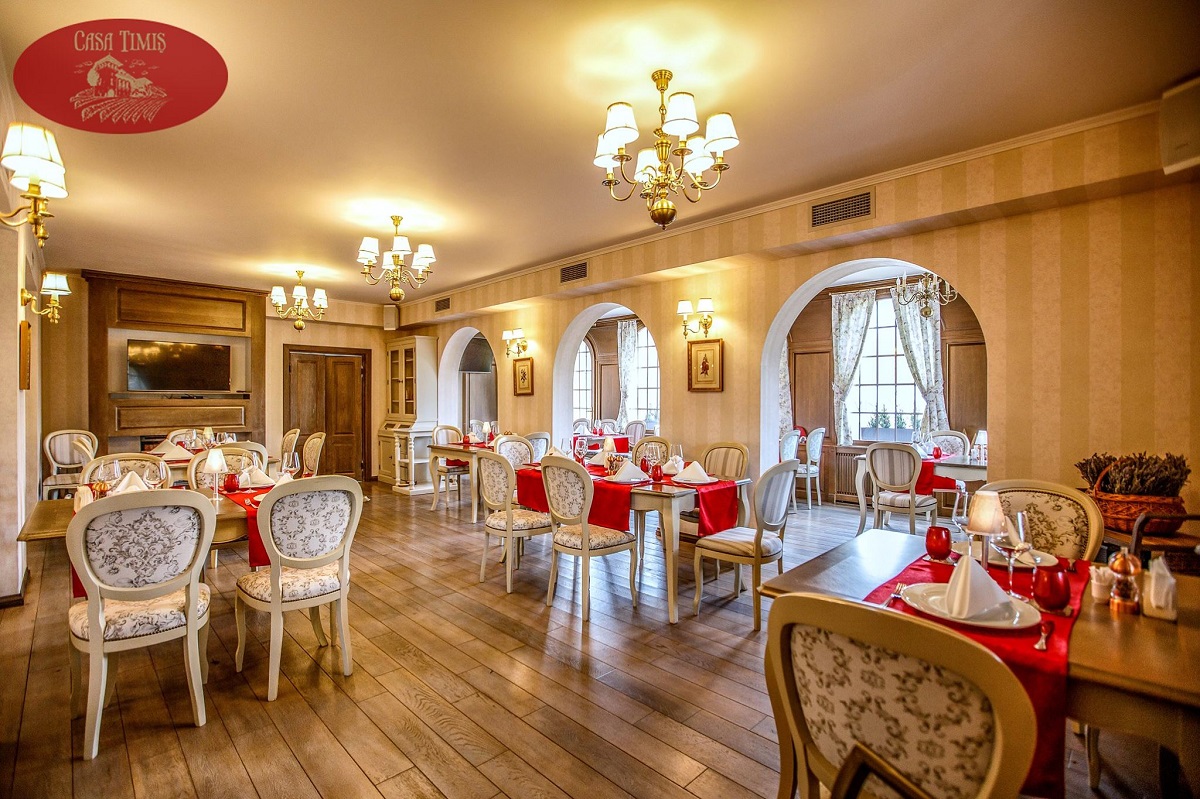 sala de la restaurant Casa Timis, cu mobilier clasic, elegant si accente decorative rosii, - destinatie experiență de Crăciun