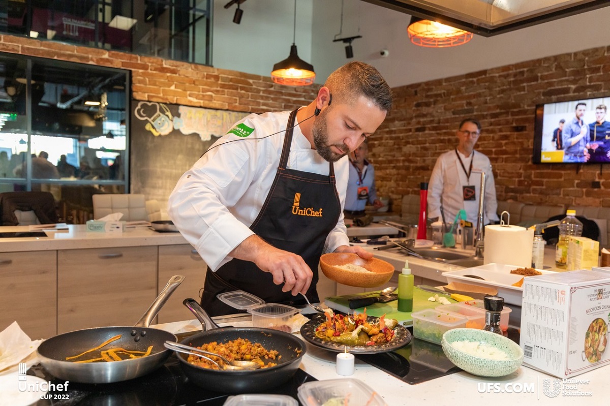 Chef Liviu Preda care prepară o rețetă vegană: lasagna descompusă cu ragu vegan, aromatizată cu busuioc și asezonată cu caju și drojdie inactivă, la gala UniChef Cup 2022