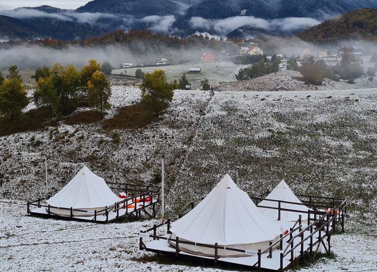 corturi de glamping la Ursa Mica Glamping Resort, fotografiate iarna, cu pajistea acoperita de un strat subtire de zapada - destinație experiență de Crăciun