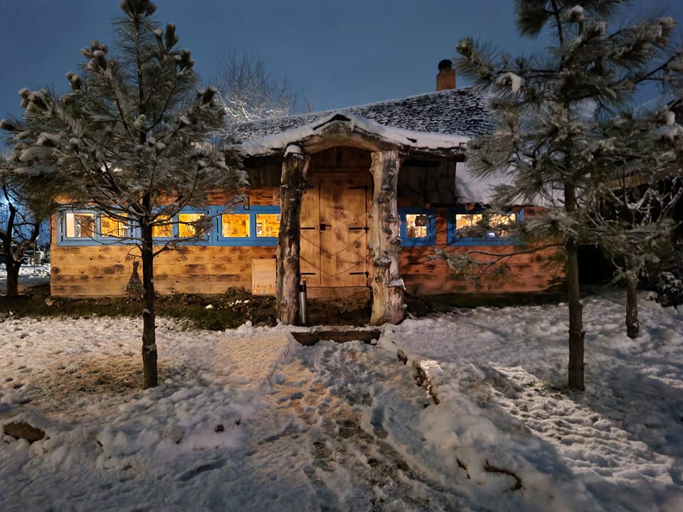 cabama de lemn fotografiata seara, iarna, cu zapada, de la Valea celor XII