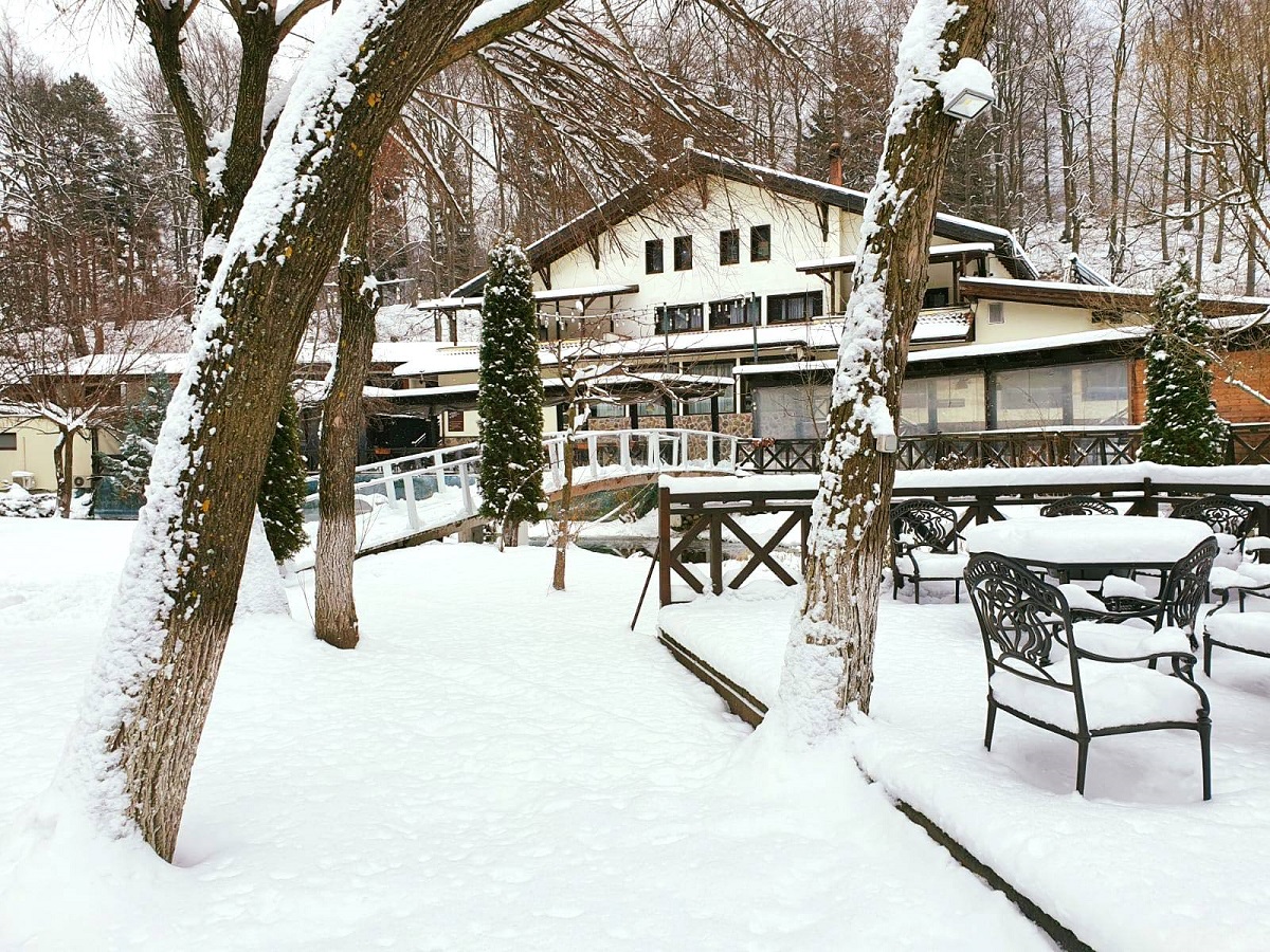 cladirea hotelului Domneiul Dâmbu Morii, fotografiata iarna, din exterior, acoperită de zăpada, unde să-ți faci Revelionul la munte la Brașov