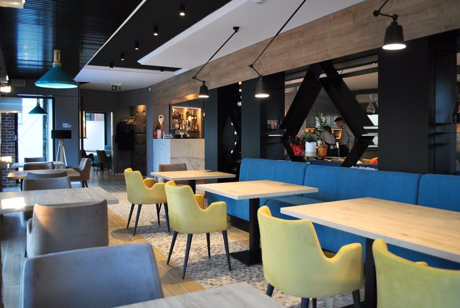 restaurant Dante Cafe & Dine cu mese cu canapele albastre si scaune crem, in Alba Iulia