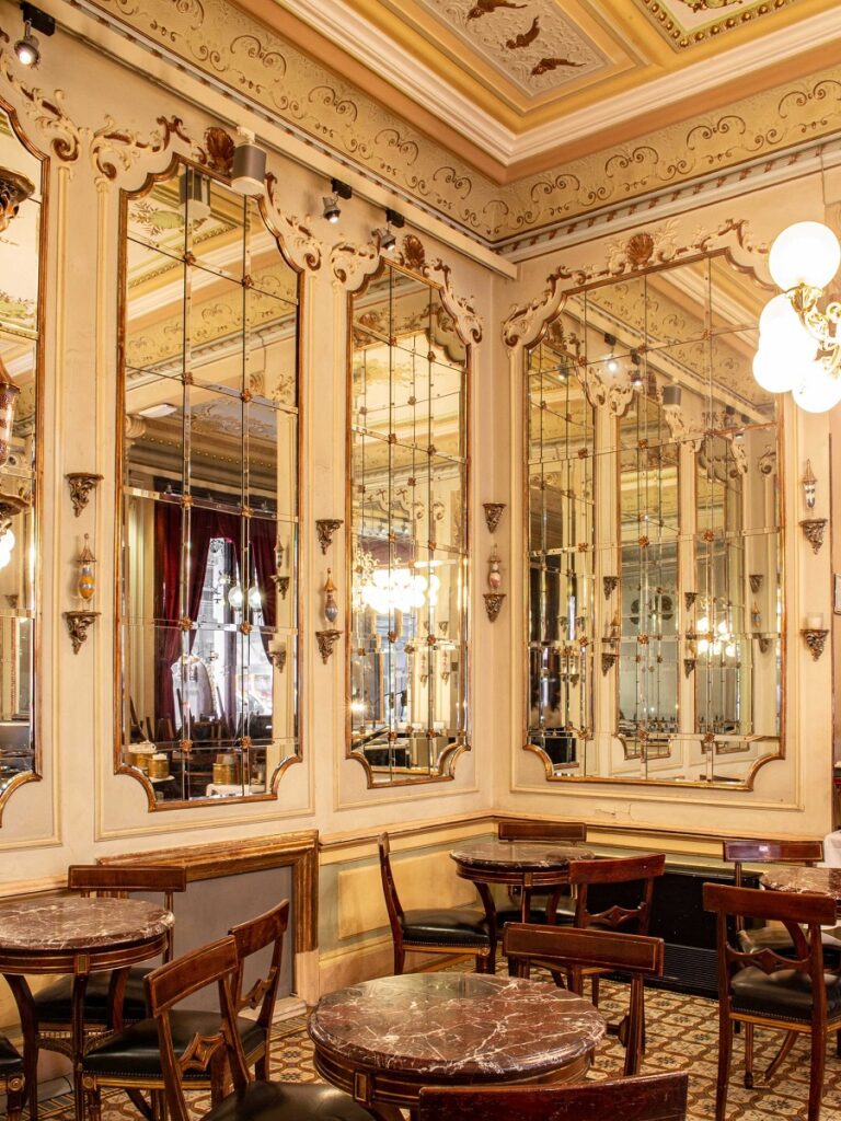 Cafeneaua Demeldin Viena, cu aspect regal, pereti cu stucaturi, decorati cu oglinzi mari, cat tot peretele si mese mici din lemn in dreptul lor