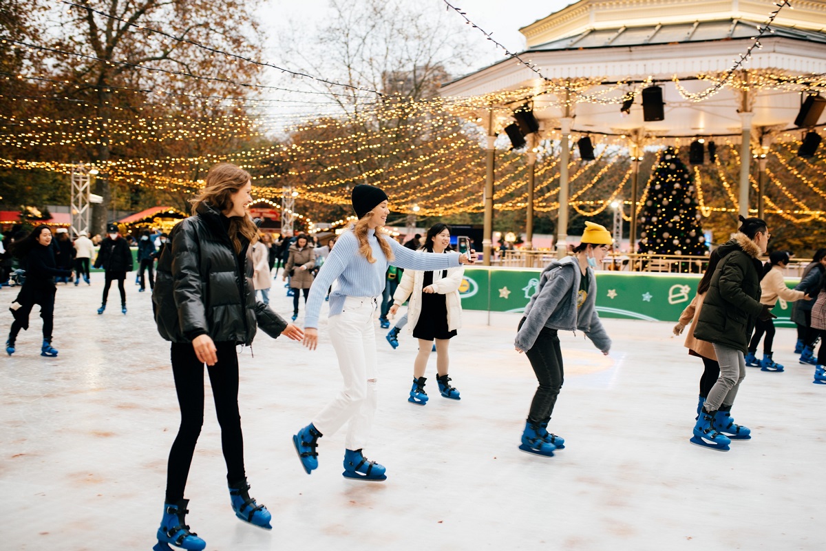 tineri care patineaza pe gheata, intr-un ring decorat cu beculete, la targul de Crăciun din Hyde PArk, Londra, Unul dintre cele mai frumoase târguri de Crăciun din Europa