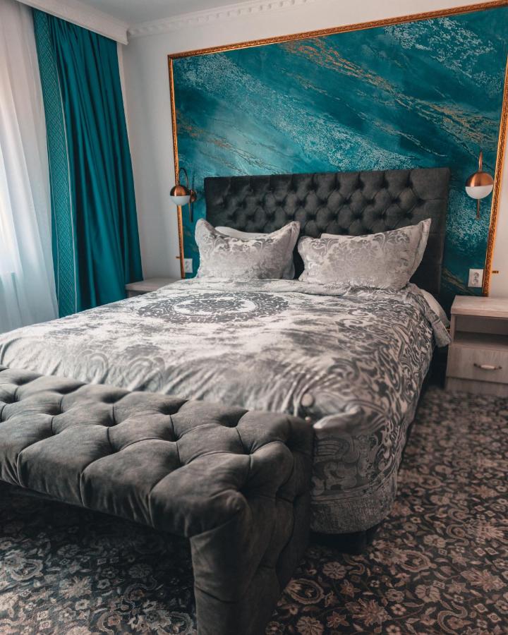 dormitor elegant cu pat capitonat si pereti vopsiti in nuante de albastru la Suru Hotel unde să faci Revelionul la munte la Bușteni