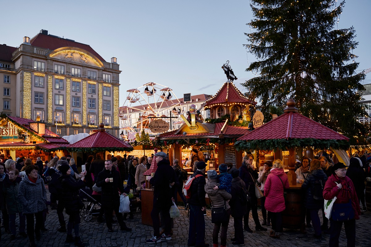 oameni care se plimba printre casutele de lemn de la targul de Crăiciun din Dresda