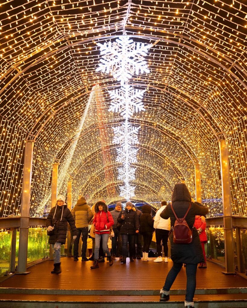 cupola de luminita aprinse, cu stelute pe mijloc, pe sub care trec oameni la târgul de Crăciun din București, unul dintre cele mai frumoase târguri de Crăciun din România