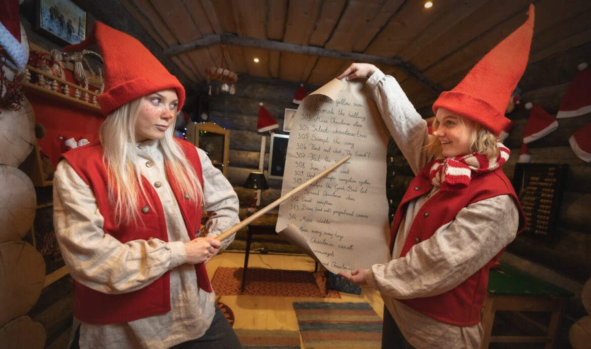 Doi spiriduși elfi ai lui Moș Crăciun care citesc lista de copii cuminti sau obraznici - la Stanta Claus Village Laponia