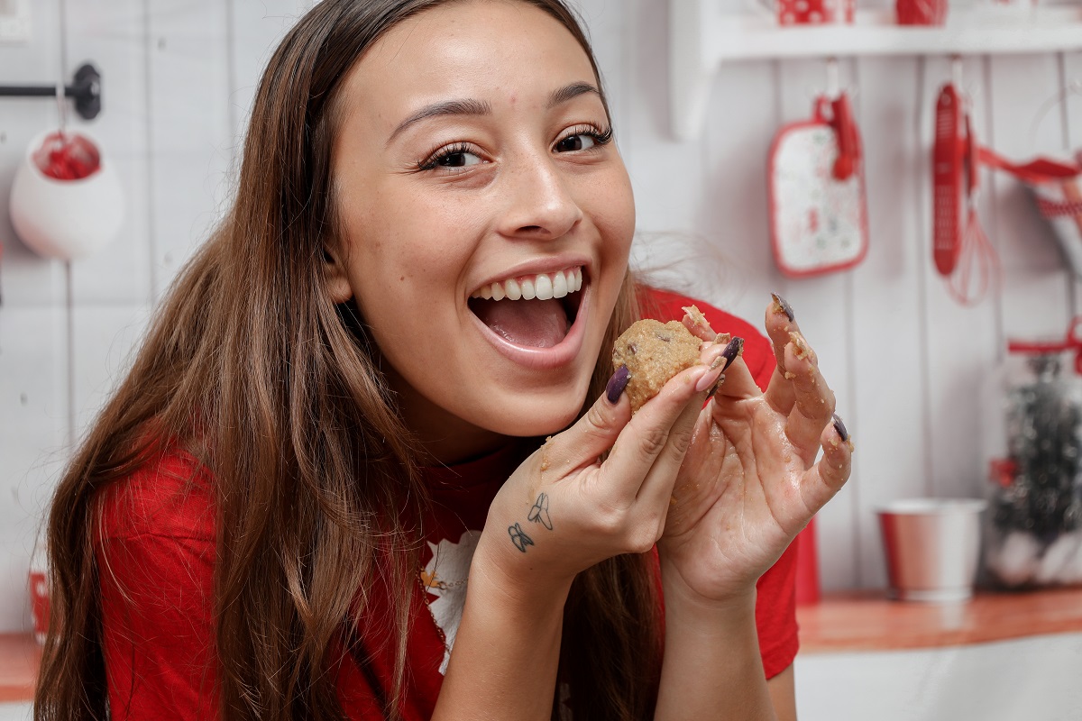 femeie fericita care musca din biscuiti de Crăciun