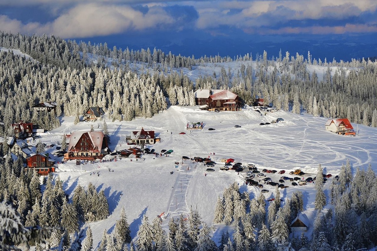 statiunea de schi de la Mădaăraș, Harghita, fotografiata de sus, din departare, cu cabane si partii si masini - una din stațiuni populare de schi din România