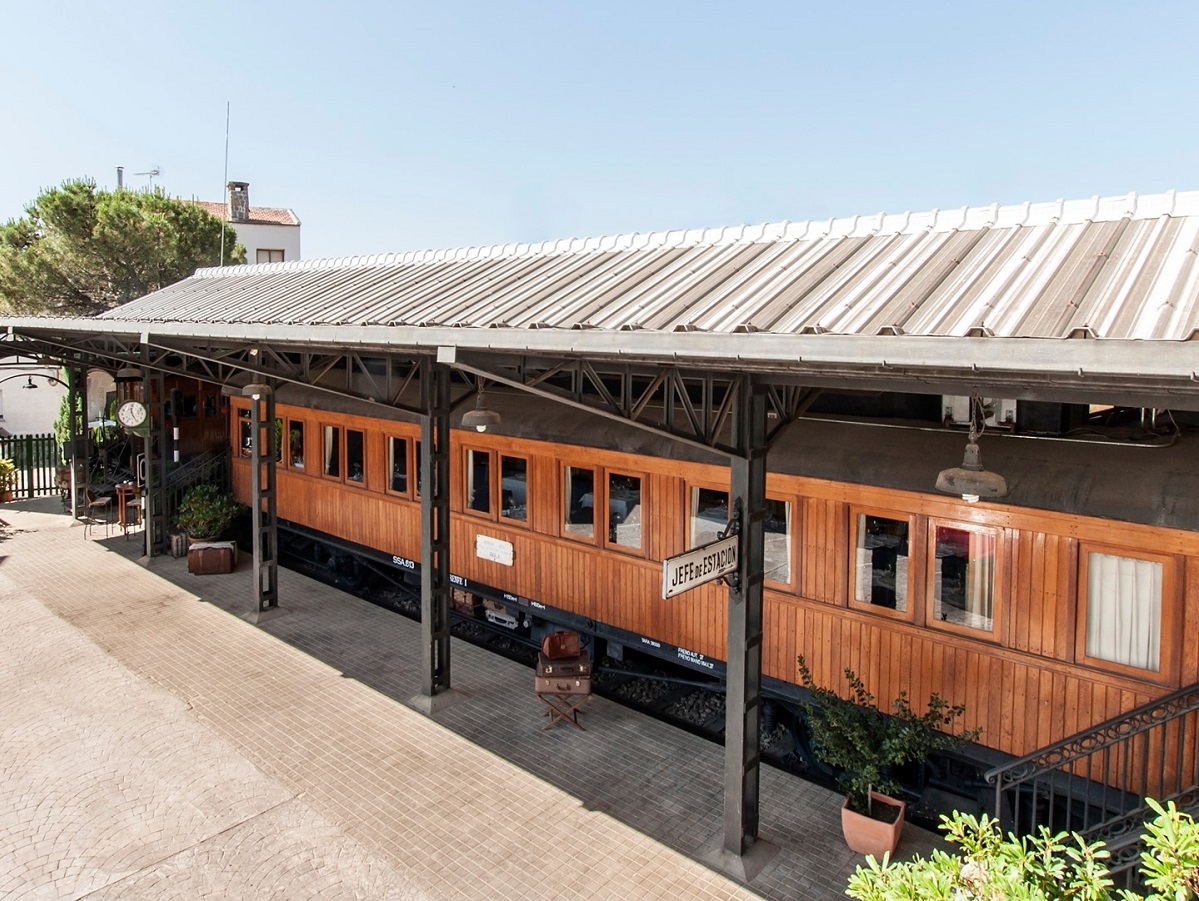 vagon de tren din lemn, asezat sub un acoperis asemanator celui dintr-o gara, care adaposteste restaurantul  El vagon de Benidin Spania