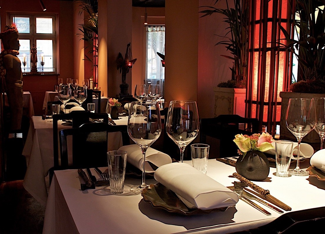 mese aranjate frumos, in lumina difuza la restaurant Khun Juk din Copenhaga, intr-o atmosferă romantică