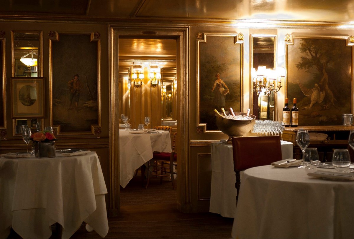 mese rotunde in restaurant Lapérouse, fotografiat seara cu lumina difuza, si tablouri clasice, unul din cele mai romantice restaurante din Europa