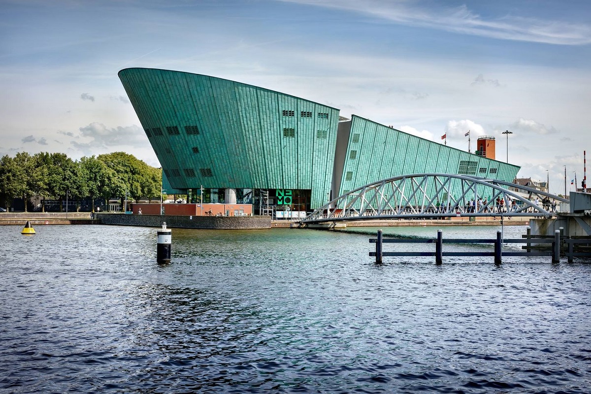  Muzeul de Științe Nemo din Amsterdam, fotografiat de afara, sub forma unui vas pe apa - una din destinații din Europa pentru vacanța din februarie