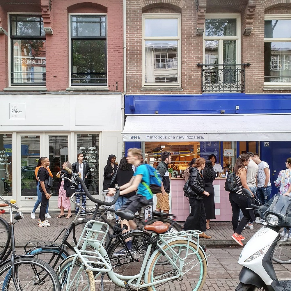 restaurant Nnea din Amsterda,m, fotografiat din afara, cu oameni care trec pe strada