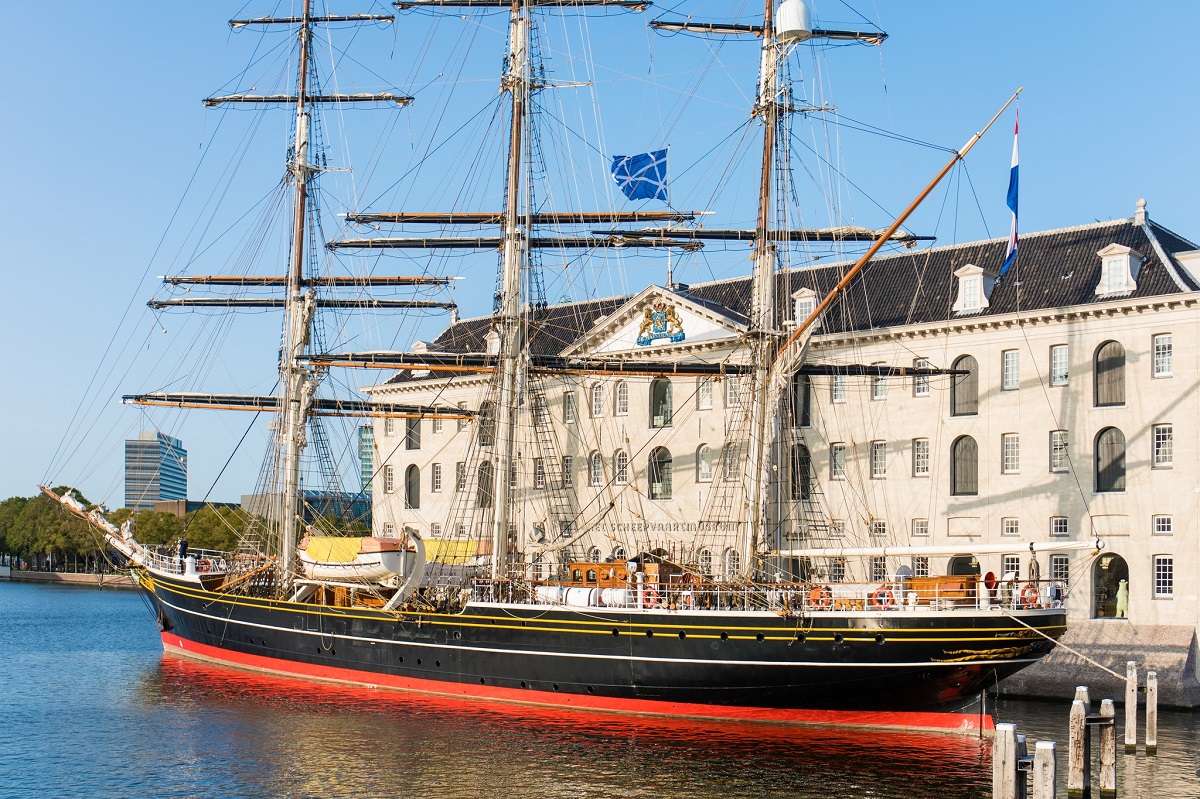cladirea Scheepvaartmuseum din Amsterdam, in fata careia se afla un vapor - una din destinații pentru vacanța din februarie